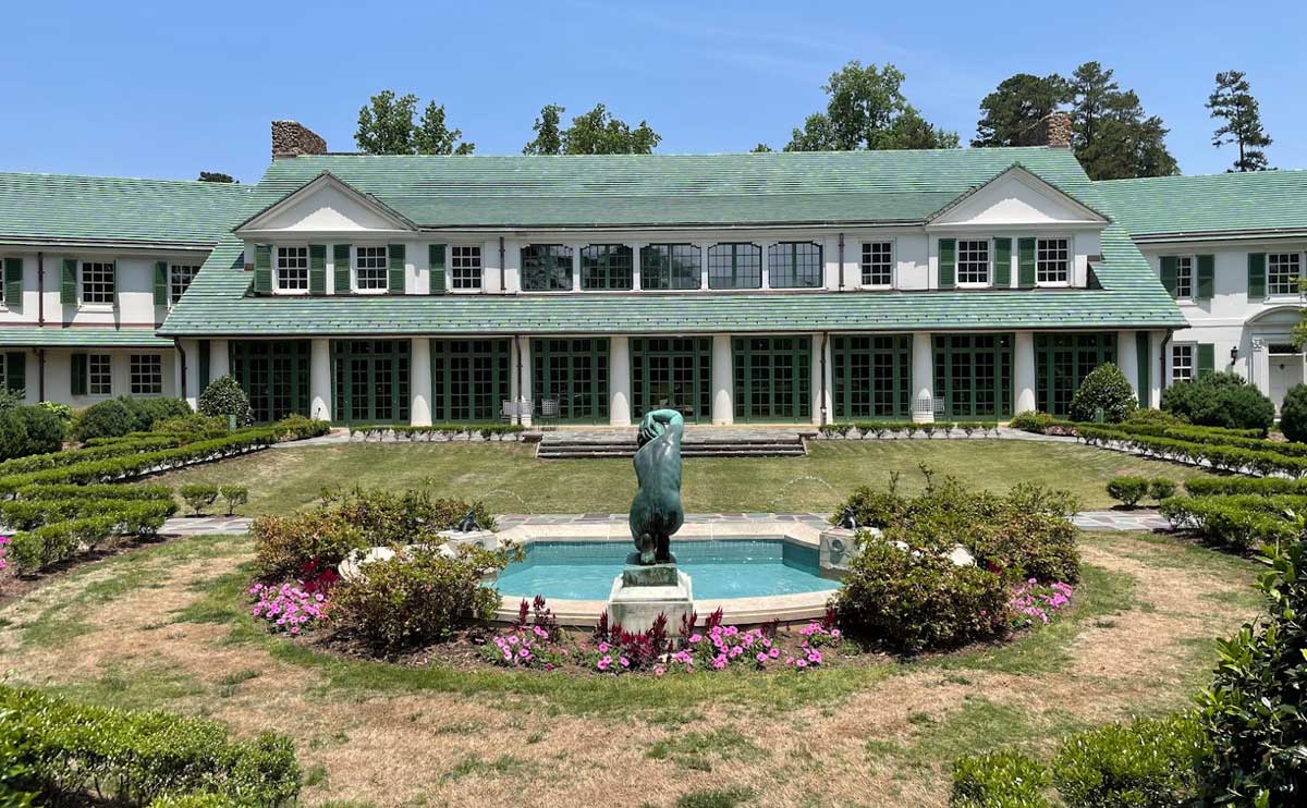 Front of reynolda house with fountain and flowers.