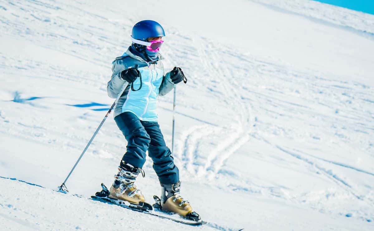 Girl skiing down slope.