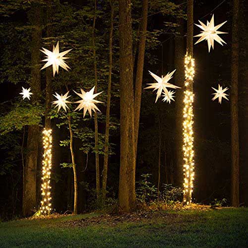Moravian stars hanging and glowing on trees at night