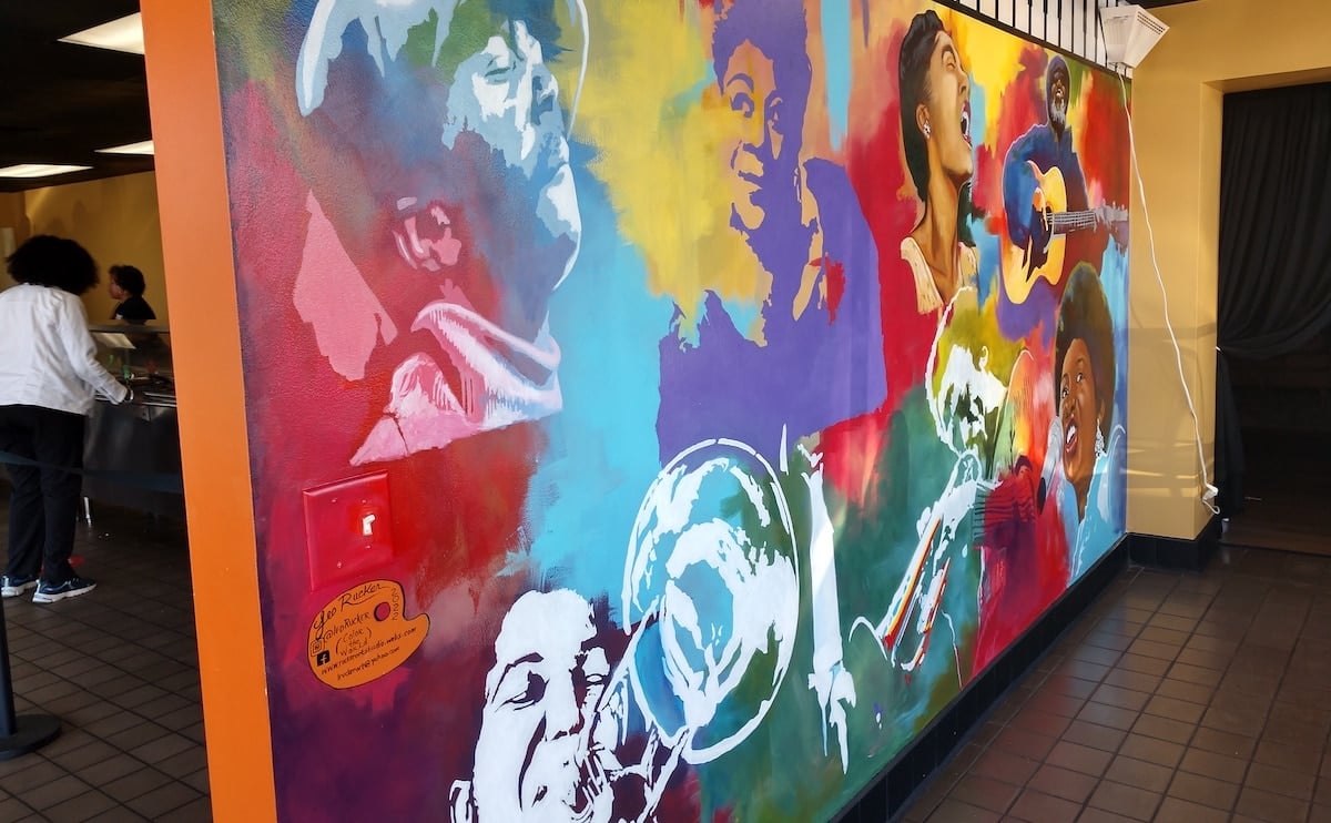 The beautiful, bright mural at Taste of the Triad, in red, purple, blues, browns, and green, depicts African Americans posing, playing instruments, and singing.