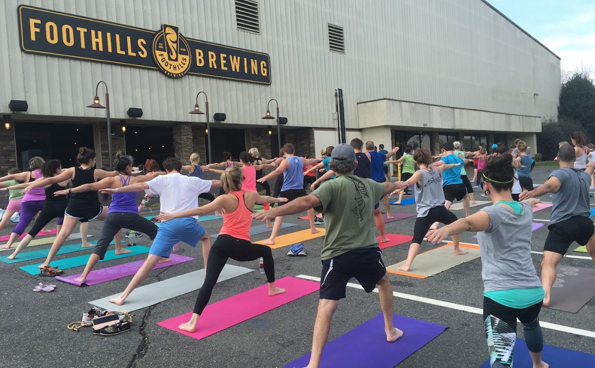 Yogamunity participants practicing yoga moves outside on mats at Foothills Brewing